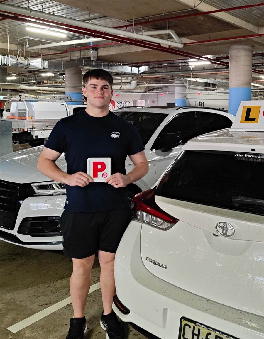 Learner driver holding P plates after driving lessons with Sydney South Driving School