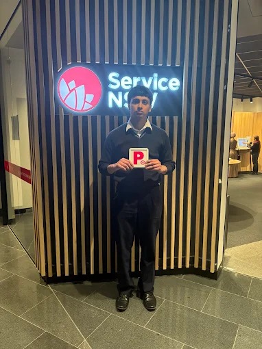 Student holding red P plates at a Service NSW centre after passing the driving test