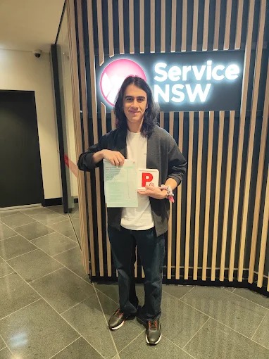 Student holding a pass certificate at a Service NSW centre